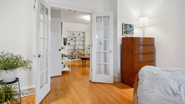 bedroom featuring french doors and light wood-style floors