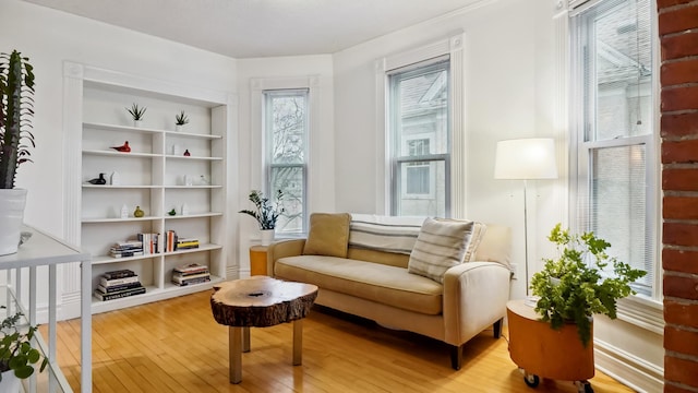 sitting room with built in shelves and light wood-style floors