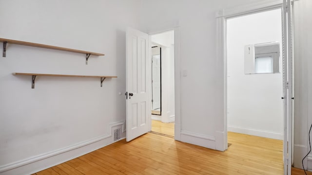 unfurnished bedroom featuring light wood finished floors, visible vents, and baseboards