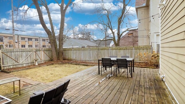 deck featuring outdoor dining area, a residential view, and a fenced backyard