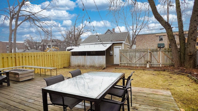 wooden deck featuring outdoor dining space, fence, and an outdoor fire pit