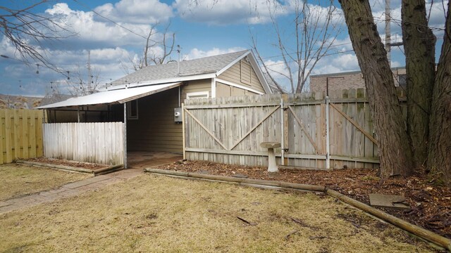 exterior space featuring a shingled roof and fence