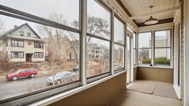 unfurnished sunroom with beamed ceiling