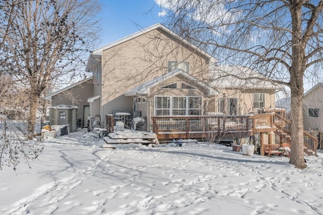 snow covered back of property featuring a wooden deck