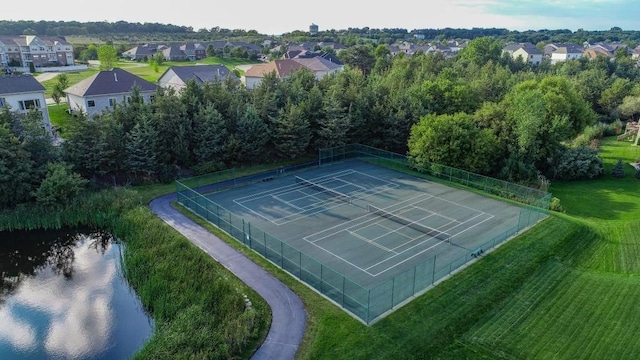 view of tennis court with a water view