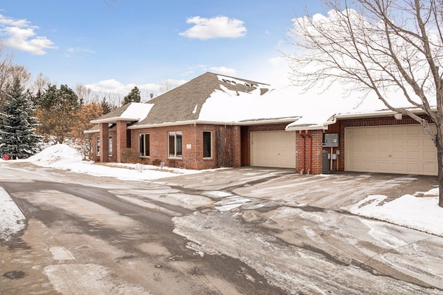 view of front of house featuring an attached garage, driveway, and brick siding