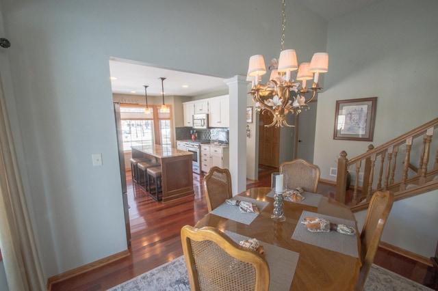 dining room featuring decorative columns, dark wood-type flooring, and an inviting chandelier