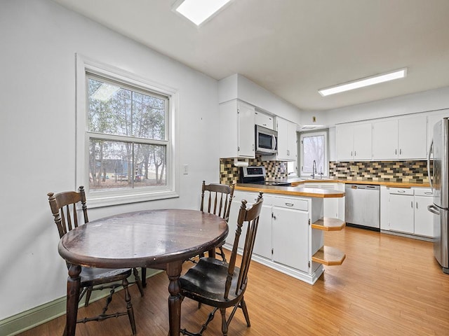230 Mcleod Ave W, Winsted, MN 55395 - kitchen featuring appliances with stainless steel finishes, tasteful backsplash, wood counters, white cabinets, and light wood-type flooring