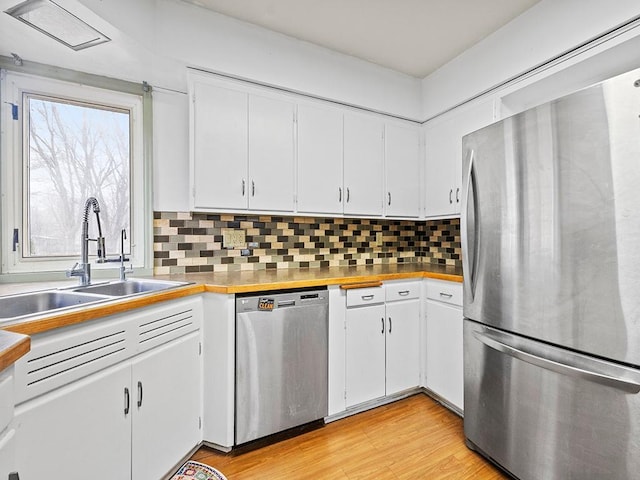230 Mcleod Ave W, Winsted, MN 55395 - kitchen featuring appliances with stainless steel finishes, a sink, white cabinets, backsplash, and light wood finished floors
