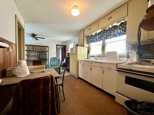 kitchen with light countertops, electric range, a ceiling fan, freestanding refrigerator, and white cabinetry