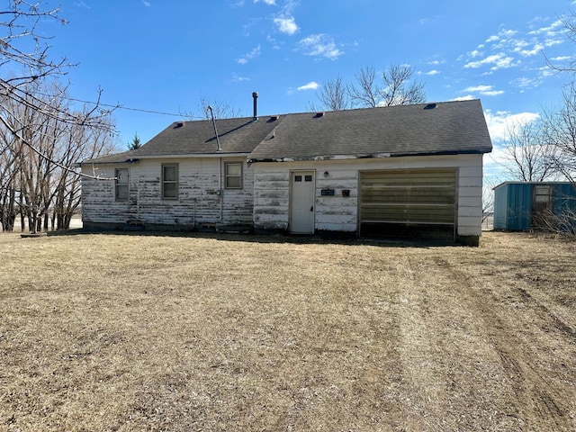 view of front of home featuring a garage and a shingled roof