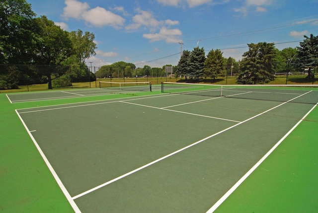 view of tennis court featuring community basketball court and fence