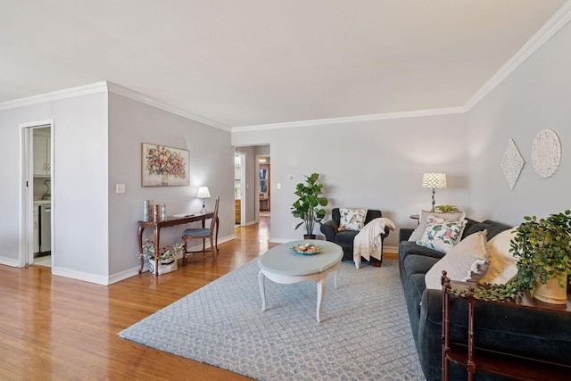 living area with baseboards, wood finished floors, and crown molding