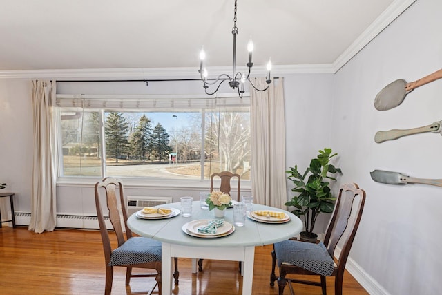 dining area with a chandelier, wood finished floors, baseboards, ornamental molding, and baseboard heating