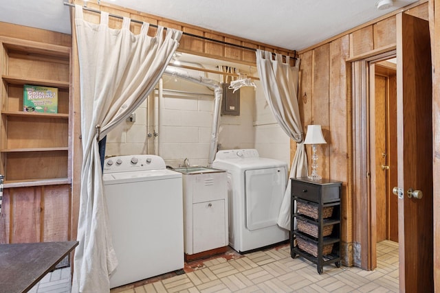 washroom with laundry area, independent washer and dryer, concrete block wall, and wooden walls