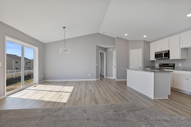 kitchen with stainless steel appliances, decorative light fixtures, a kitchen island, and white cabinets