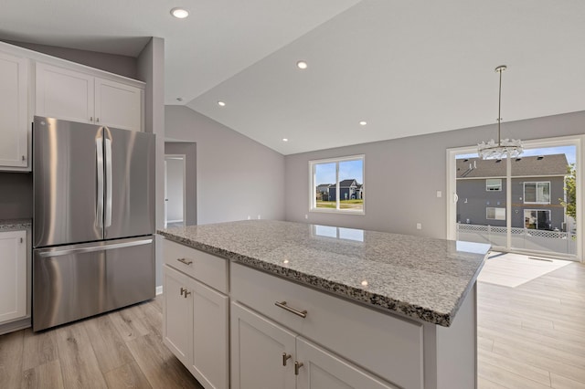 kitchen featuring stainless steel fridge, a center island, and white cabinets