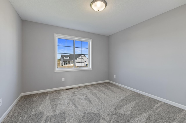 spare room featuring carpet floors and a textured ceiling