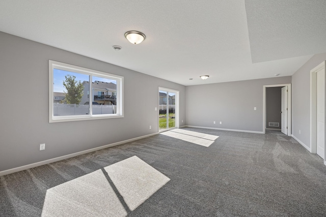 spare room featuring carpet flooring and a textured ceiling