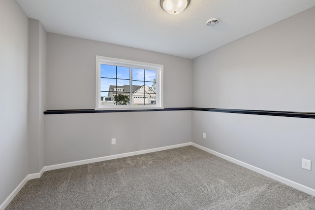 carpeted empty room featuring a textured ceiling