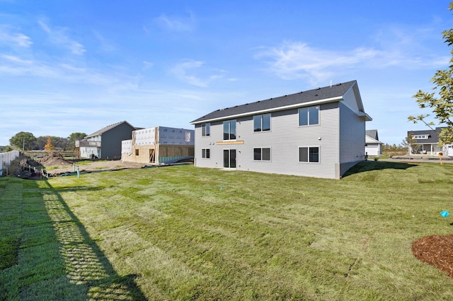 rear view of house featuring a yard