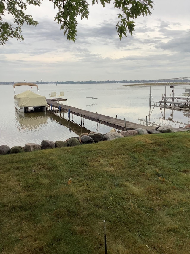 dock area featuring a water view and a lawn