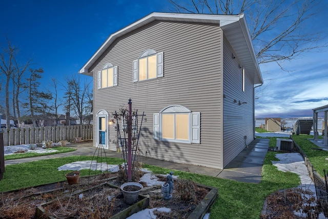 view of property exterior with a vegetable garden, a patio, and fence