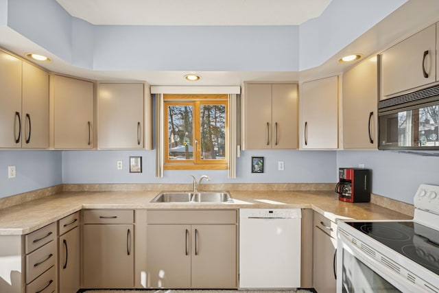 kitchen featuring white appliances, light countertops, a sink, and cream cabinetry