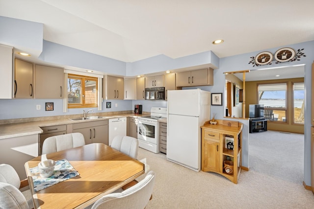 kitchen with recessed lighting, light colored carpet, white appliances, a sink, and light countertops