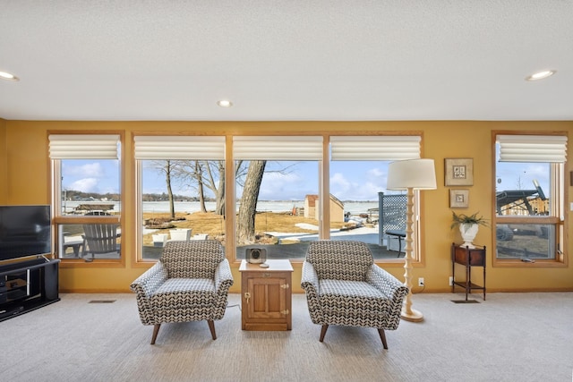 sitting room with light colored carpet, a healthy amount of sunlight, and recessed lighting