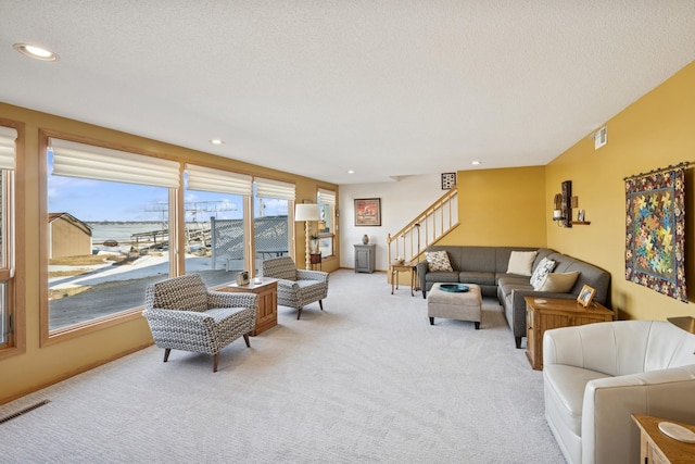 living room with visible vents, light colored carpet, stairway, a textured ceiling, and recessed lighting