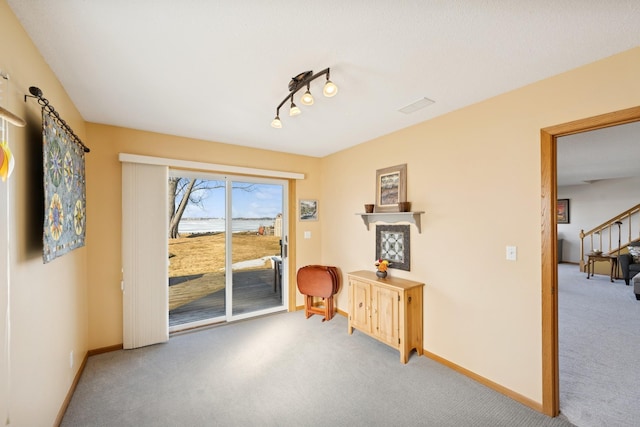 interior space with carpet floors, visible vents, stairway, and baseboards