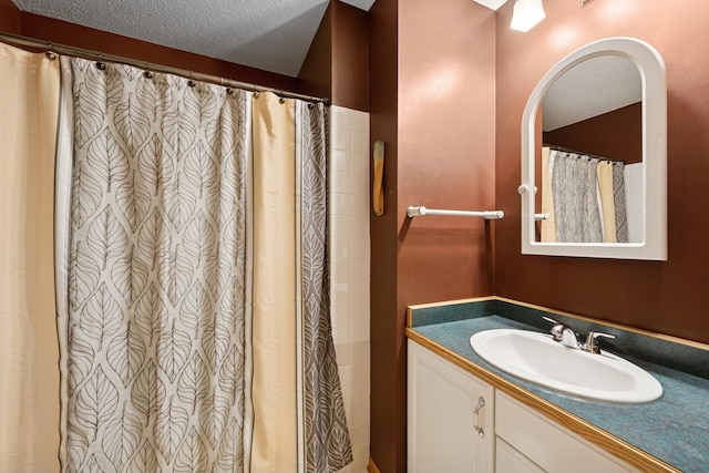 full bathroom with a textured ceiling and vanity