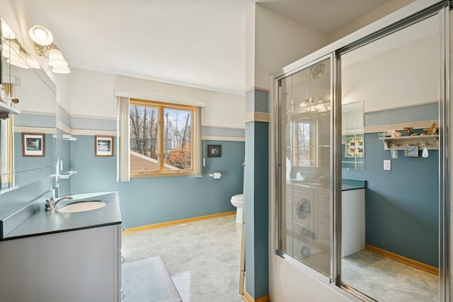 bathroom with baseboards, shower / bath combination with glass door, vanity, and toilet