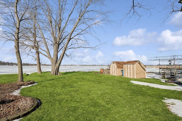 view of yard with a water view, a storage unit, and an outdoor structure