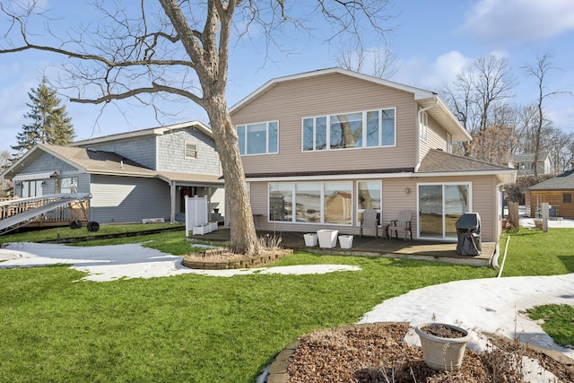 rear view of property featuring roof with shingles, a patio, and a yard