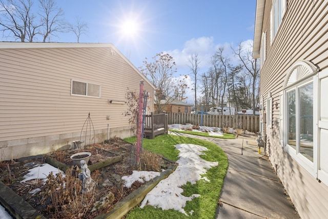 view of yard featuring a patio, fence, and a vegetable garden