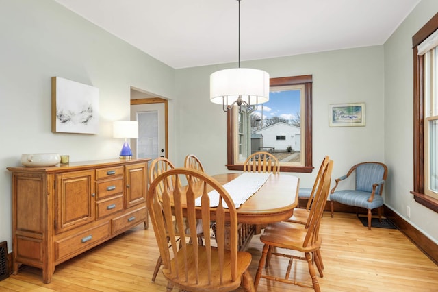 dining space with baseboards, visible vents, and light wood-style floors