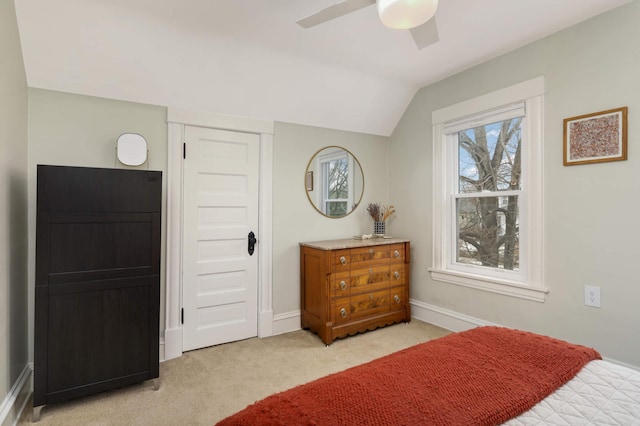 bedroom featuring a ceiling fan, lofted ceiling, light colored carpet, and baseboards