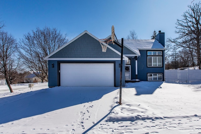 view of front of property with a chimney, an attached garage, and fence