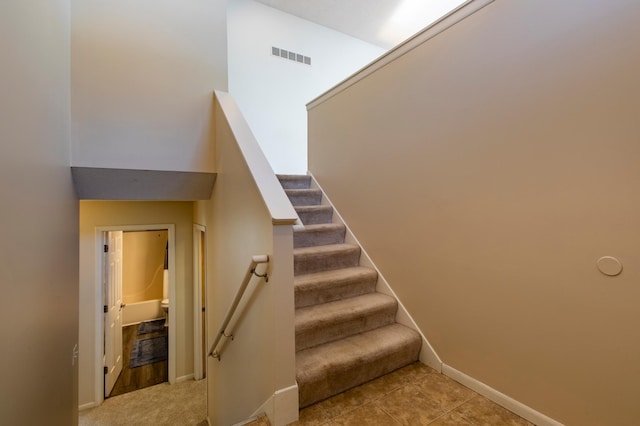 stairs with baseboards, visible vents, and tile patterned floors