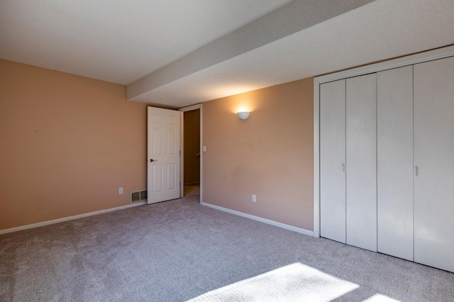 unfurnished bedroom featuring carpet flooring, baseboards, and a closet