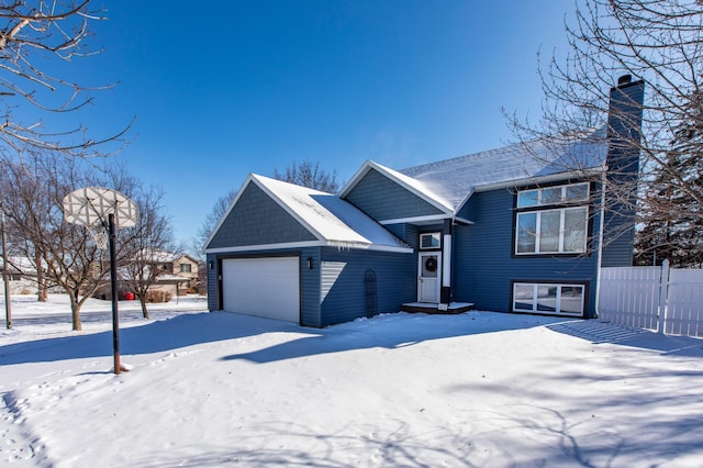 tri-level home featuring a garage and a chimney