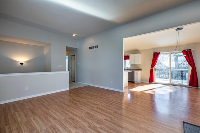 empty room featuring light wood finished floors and baseboards