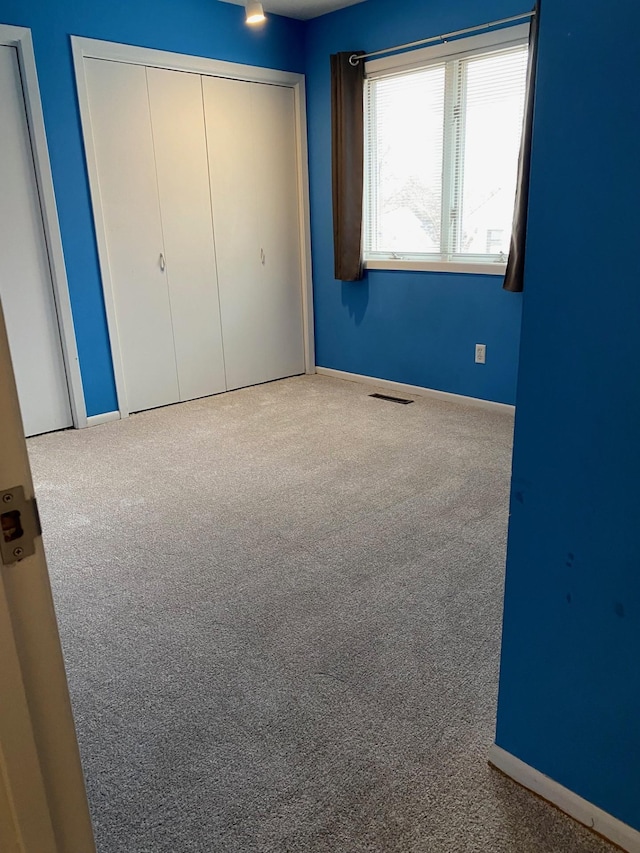 unfurnished bedroom with carpet and baseboards