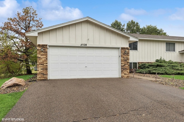 2528 Birchview Ln, Minnetonka, MN 55305 - single story home featuring brick siding, driveway, board and batten siding, a garage, and roof with shingles