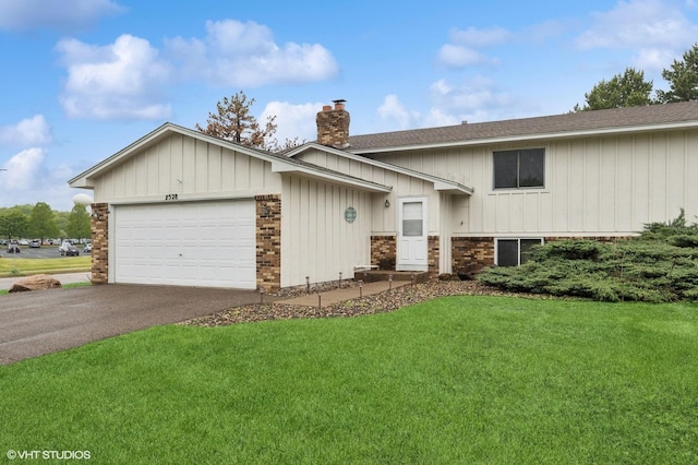 2528 Birchview Ln, Minnetonka, MN 55305 - view of front of house with a chimney, asphalt driveway, a front yard, a garage, and board and batten siding