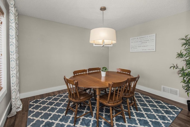 dining room featuring dark hardwood / wood-style floors and a textured ceiling