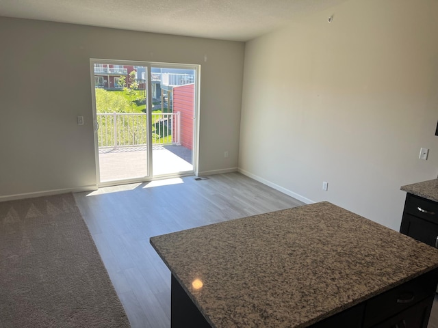 interior space with light hardwood / wood-style floors, a kitchen island, and a textured ceiling