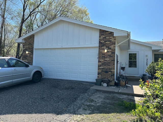 2509 Birchview Ln, Minnetonka, MN 55305 - view of property exterior with brick siding, board and batten siding, an attached garage, and asphalt driveway